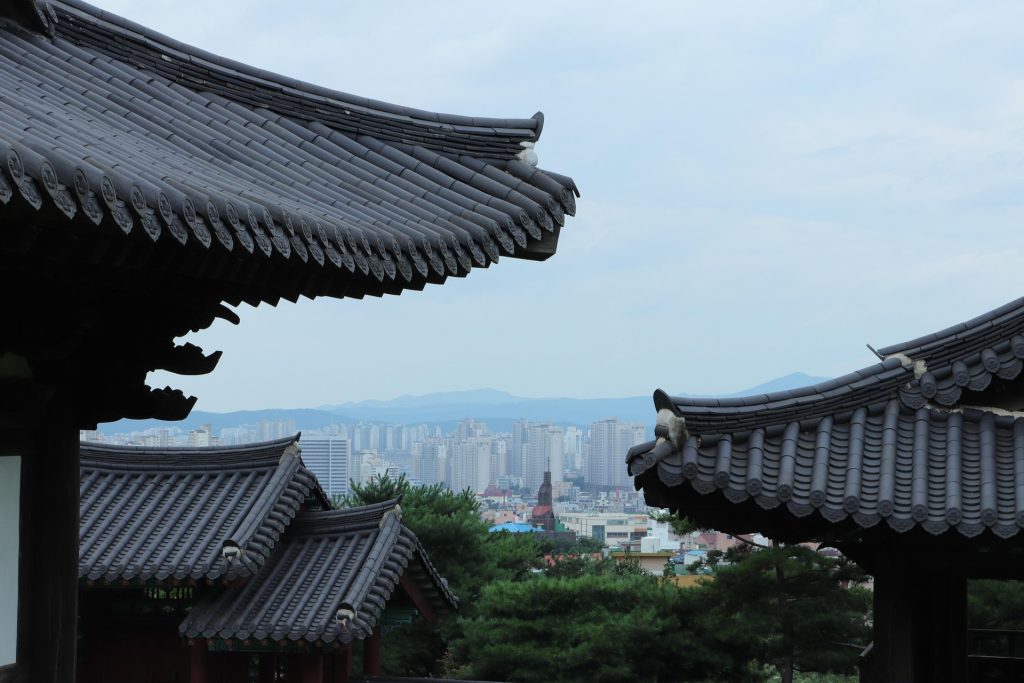 Traditional Korean tiled rooftops overlooking a modern city skyline in South Korea