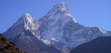 Snow-capped Himalayan mountain peaks beneath a clear blue sky in Nepal