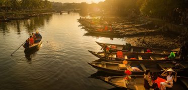 Traditional wooden boats on a calm river at sunset